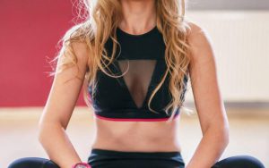 Kobieta z różowym zegarkiem siedząca na karimacie